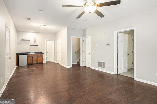 unfurnished living room with dark hardwood / wood-style flooring and ceiling fan