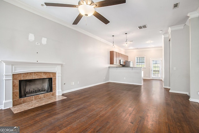unfurnished living room with a tile fireplace, ceiling fan, dark hardwood / wood-style floors, and ornamental molding