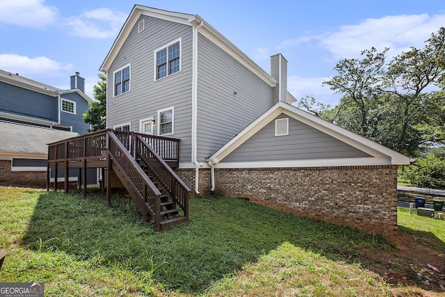 rear view of house featuring a yard and a wooden deck