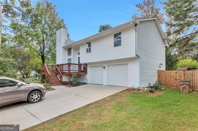 view of front of house featuring a garage, a front lawn, and a wooden deck