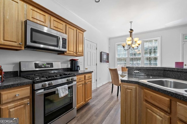 kitchen featuring an inviting chandelier, appliances with stainless steel finishes, wood-type flooring, crown molding, and pendant lighting