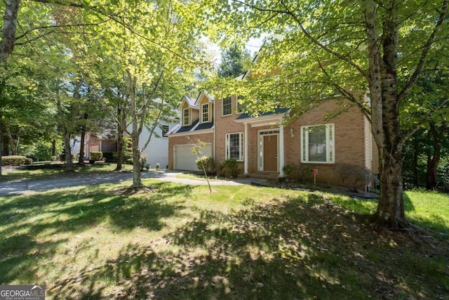 view of property with a garage and a front lawn