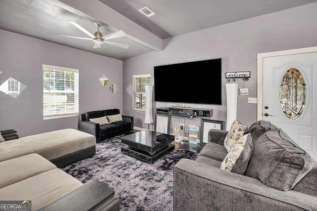 living room with ceiling fan and lofted ceiling with beams