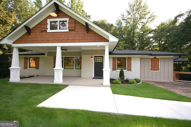 view of front facade featuring ceiling fan, covered porch, and a front lawn