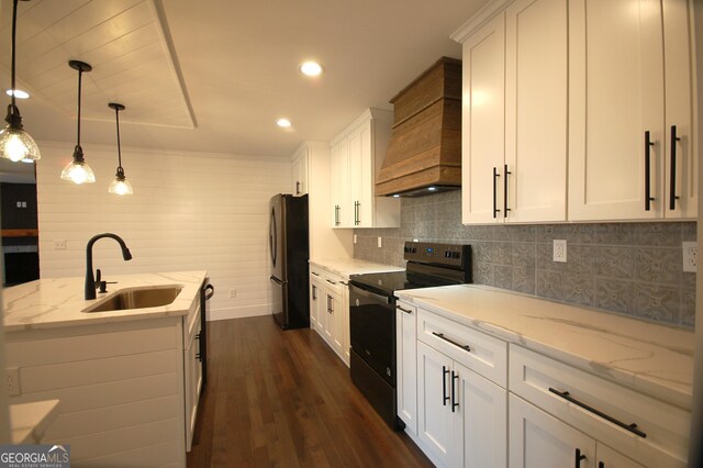 kitchen with black appliances, custom range hood, and white cabinets