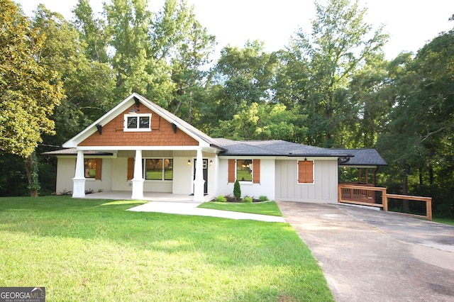 view of front of home with covered porch and a front lawn