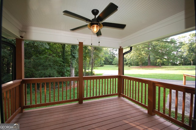 deck featuring ceiling fan and a lawn