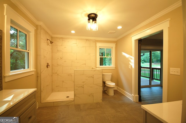 bathroom featuring vanity, crown molding, toilet, and tiled shower