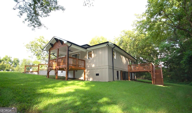 back of house featuring a lawn, ceiling fan, and a deck