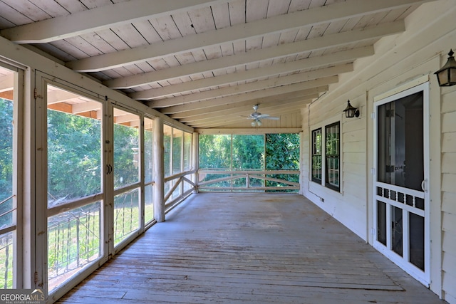 unfurnished sunroom with wooden ceiling, a ceiling fan, and beamed ceiling