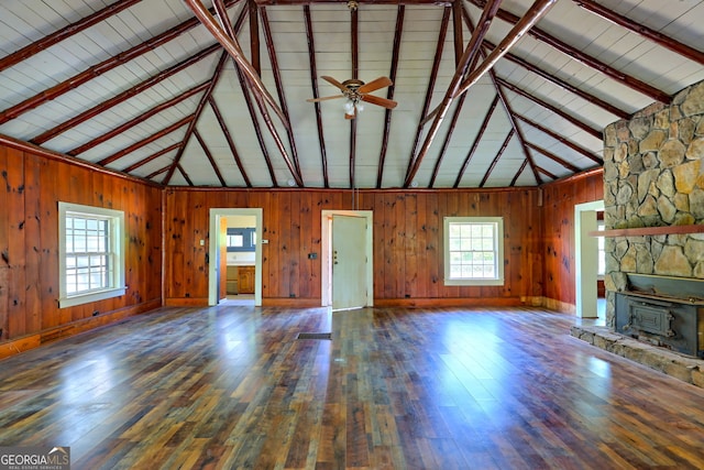 unfurnished living room with hardwood / wood-style flooring, beam ceiling, and a fireplace