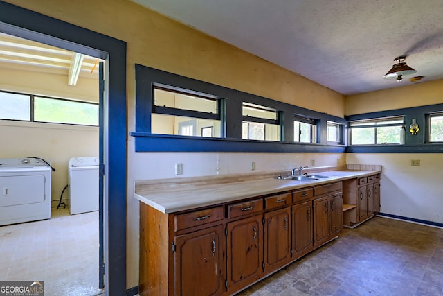 kitchen featuring sink, independent washer and dryer, and light tile patterned floors