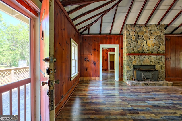 entrance foyer with beamed ceiling, high vaulted ceiling, wood walls, and wood finished floors