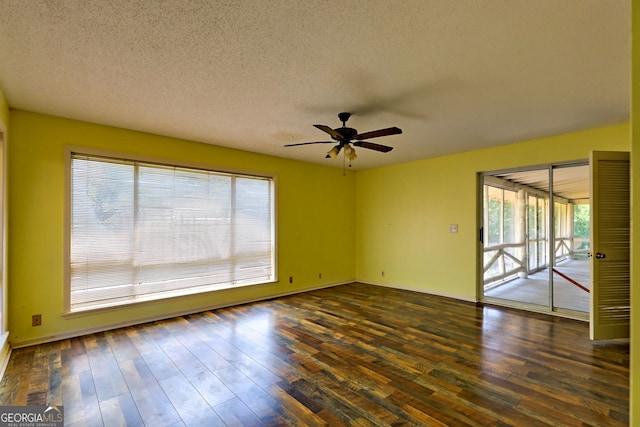 empty room featuring ceiling fan, a textured ceiling, and dark wood-type flooring