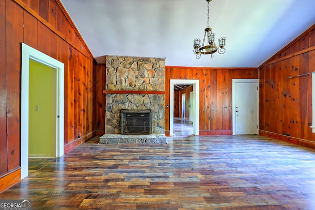 unfurnished living room featuring a fireplace, wooden walls, lofted ceiling, and hardwood / wood-style floors