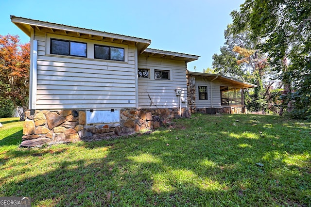 rear view of house featuring a yard and cooling unit