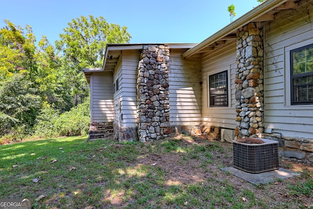 view of home's exterior featuring central AC and a yard