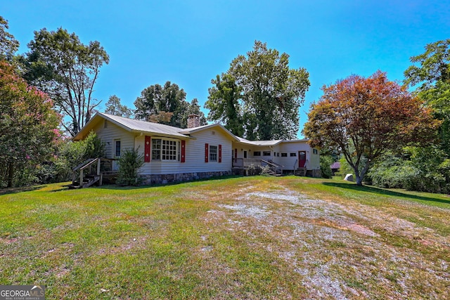 view of front of property featuring a chimney, metal roof, and a front yard