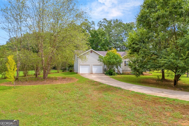 view of property hidden behind natural elements featuring a front lawn and a garage