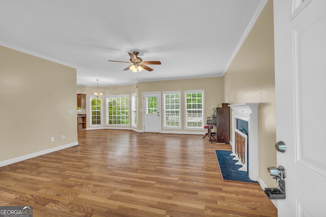 unfurnished living room featuring ornamental molding, hardwood / wood-style floors, and ceiling fan with notable chandelier