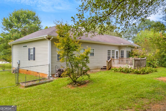 rear view of house featuring crawl space, a yard, a gate, fence, and a wooden deck