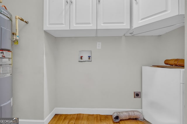 laundry area with hookup for an electric dryer, washer hookup, light wood-type flooring, and cabinets