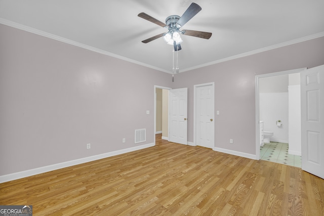 unfurnished bedroom featuring ensuite bathroom, light wood-style flooring, visible vents, baseboards, and ornamental molding