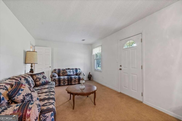 living room featuring light colored carpet and a textured ceiling