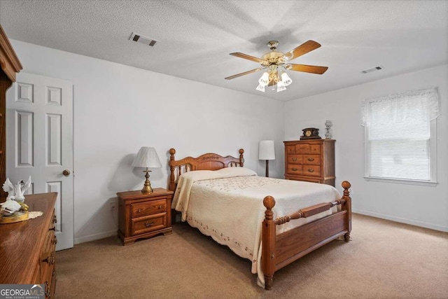 carpeted bedroom featuring a textured ceiling and ceiling fan