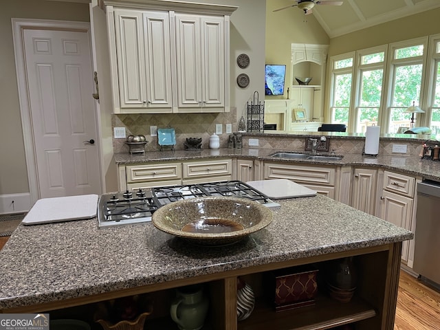 kitchen with ceiling fan, light hardwood / wood-style flooring, sink, dark stone countertops, and lofted ceiling