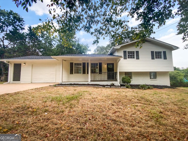 split level home featuring covered porch, a front lawn, and a garage