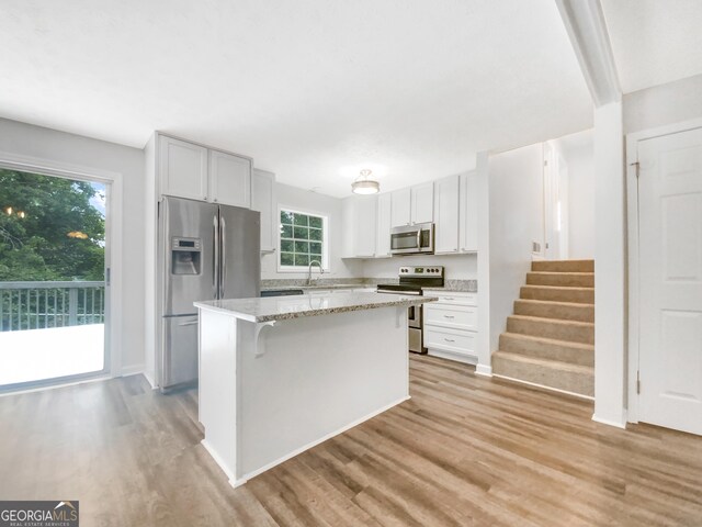 kitchen with a wealth of natural light, stainless steel appliances, and light hardwood / wood-style flooring