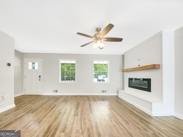 unfurnished living room featuring ceiling fan and light wood-type flooring