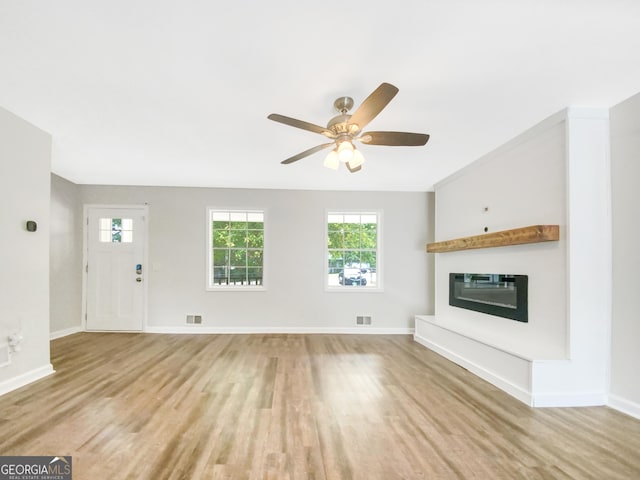 unfurnished living room with light wood-type flooring and ceiling fan