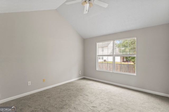 carpeted spare room with a textured ceiling, lofted ceiling, and ceiling fan