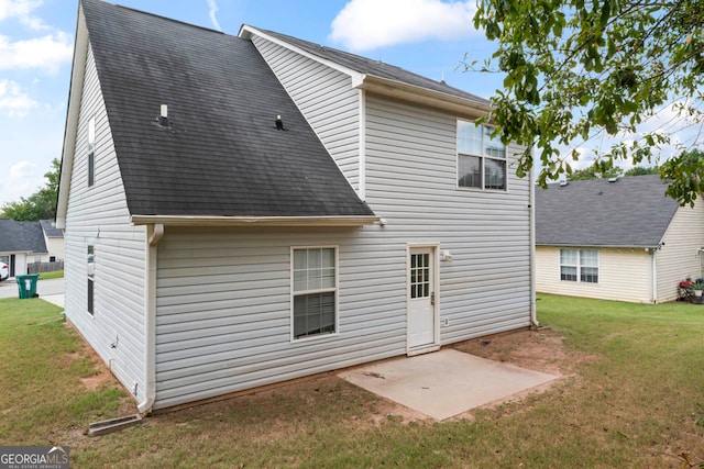 rear view of property with a yard and a patio