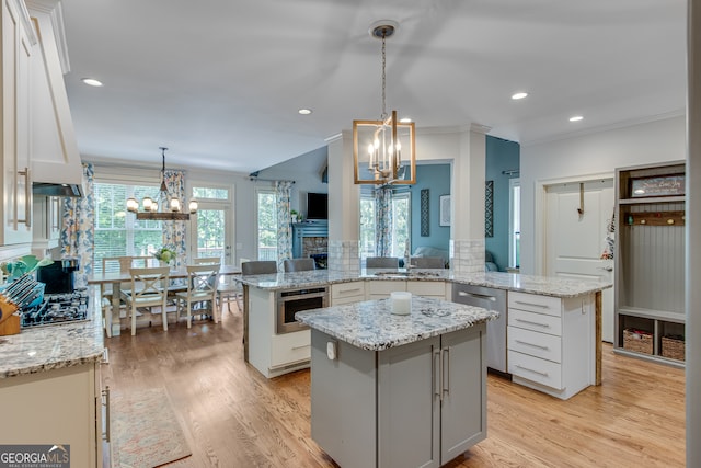 kitchen featuring light hardwood / wood-style flooring, white cabinetry, pendant lighting, and a kitchen island