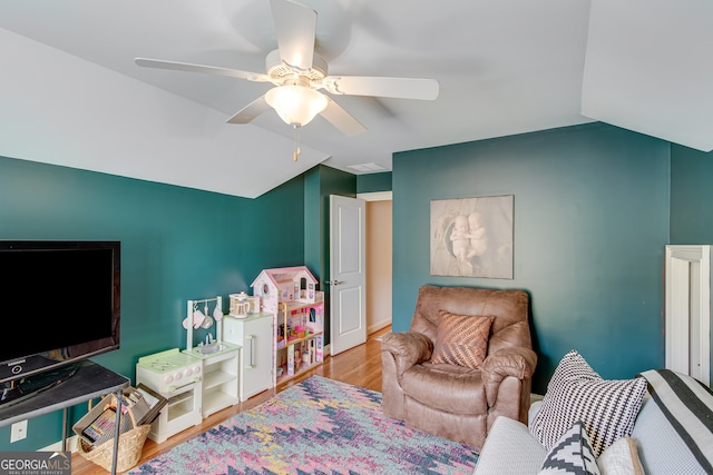 living room with ceiling fan, light wood-type flooring, and vaulted ceiling