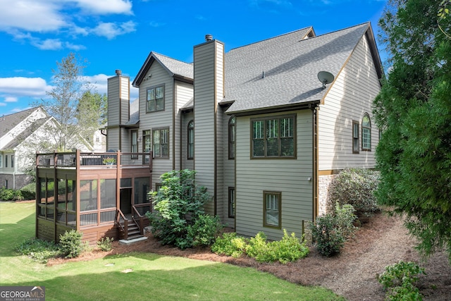 back of property with a sunroom and a yard