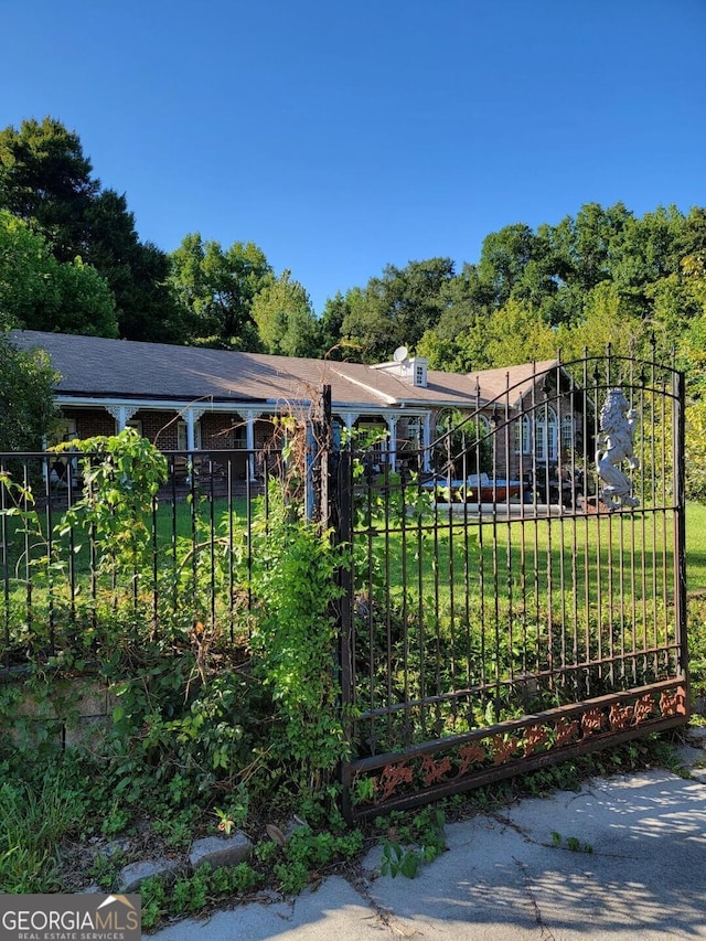 view of gate featuring a lawn