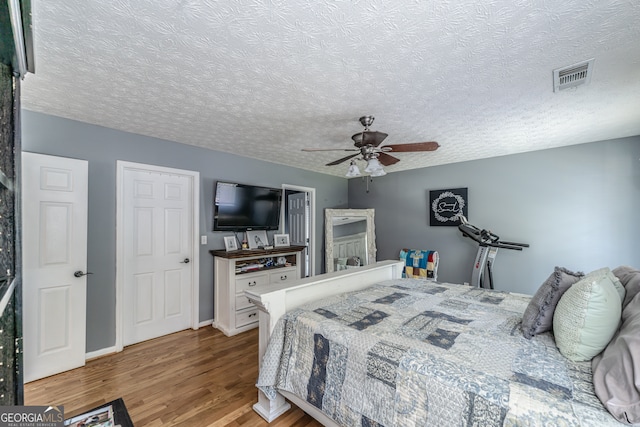 bedroom featuring a textured ceiling, ceiling fan, and hardwood / wood-style floors