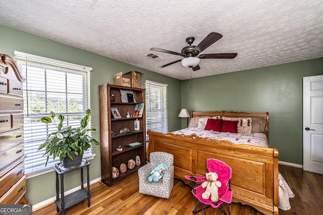 bedroom with hardwood / wood-style flooring, a textured ceiling, and ceiling fan