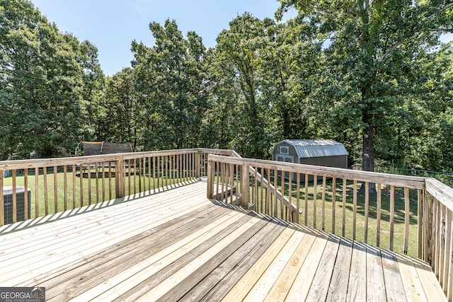 wooden deck with a trampoline, central air condition unit, a lawn, and a storage unit