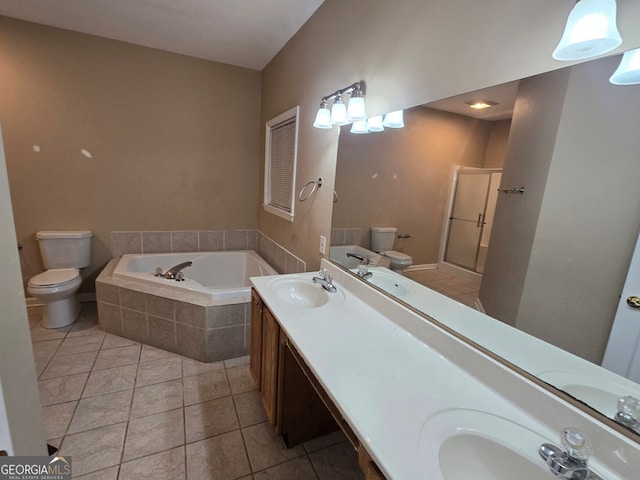 bathroom featuring tiled tub, vanity, toilet, and tile patterned floors