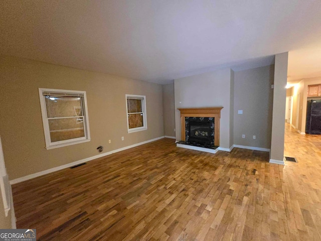 unfurnished living room with a fireplace and light hardwood / wood-style floors