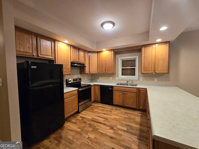 kitchen with light hardwood / wood-style floors, black appliances, and sink