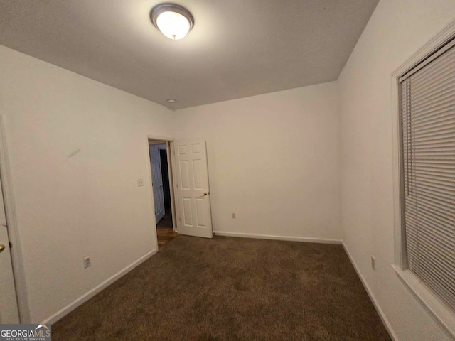 unfurnished bedroom featuring dark carpet