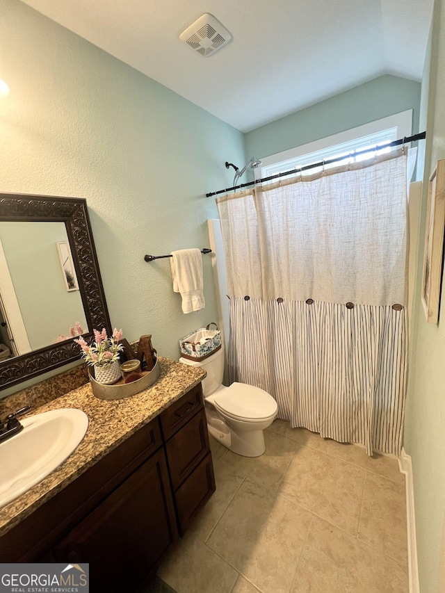 bathroom with visible vents, toilet, lofted ceiling, tile patterned floors, and vanity