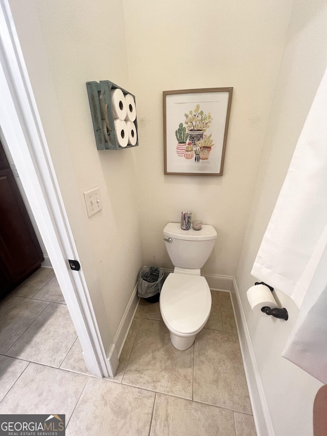 bathroom featuring baseboards, toilet, and tile patterned floors