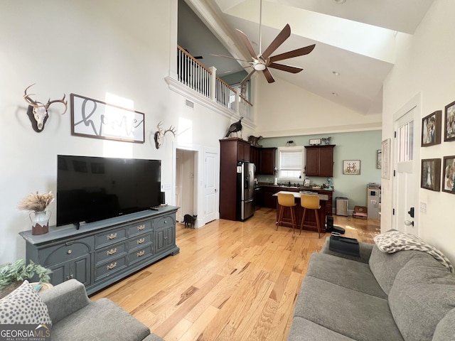 living area with light wood-style flooring, visible vents, and ceiling fan